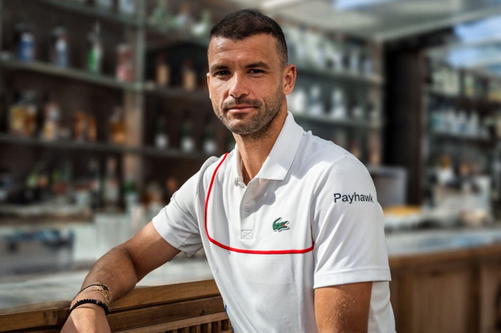 A portrait shot of Grigor Dimitrov wearing a tennis jersey with a Payhawk logo